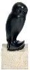 une statue représentant un oiseau noir perché sur un bloc de pierre