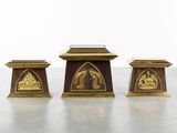 three brass - plated pedestals in the shape of a man and woman