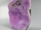 a close up of a purple rock on a white surface