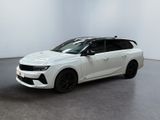 Une voiture blanche est garée dans une pièce blanche au sol noir.