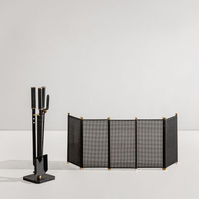 the black and gold fireplace screen is next to a black and white fireplace