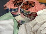 a pile of clothes on the floor next to a bed
