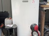 un petit réfrigérateur blanc posé sur une palette