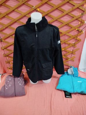 une veste noire et une veste bleue posées sur un lit rose