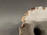 a close up of a white vase with a hole in it