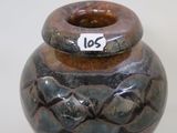 a brown and black vase with a tag on it