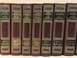 six livres alignés sur une table, devant un fond blanc