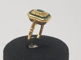 an image of a gold ring with a green stone in it