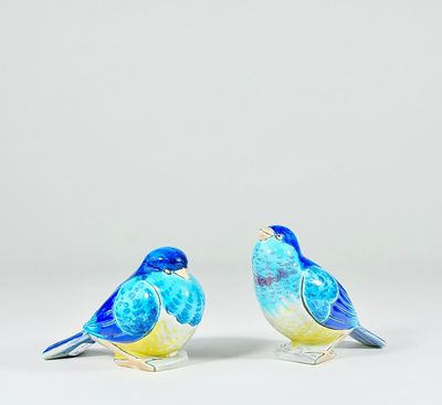 pair of blue and yellow bird figurines sitting on a white surface