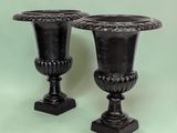 two black vases sitting next to each other on a table