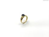 a close up of a gold ring with a sapphire stone