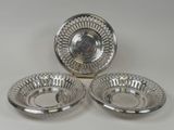 trois assiettes en métal argenté sur fond blanc