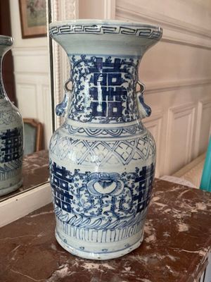 a blue and white vase sitting on a table in front of a mirror