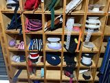 a wooden rack with many pairs of shoes and umbrellas on it