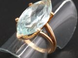 un gros plan d'une bague sertie d'une aigue-marine sur un fond noir