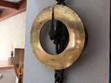 a clock hanging on the wall with a hook on it