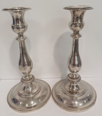 paire de chandeliers en métal argenté sur fond blanc