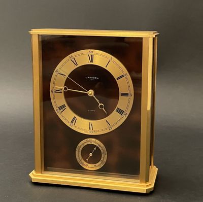a gold clock with roman numerals on the face