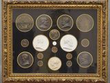 a framed picture of a group of coins with a picture of a man and a woman