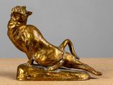 bronze statue of a cat on a rock on a table