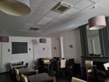 tables and chairs in a room with a flat screen tv on the wall