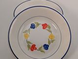 two plates with flowers on them on a white table