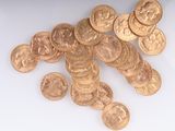 une pile de pièces d'or posée sur une surface blanche
