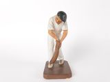 figurine of a baseball player with a bat on a wooden base