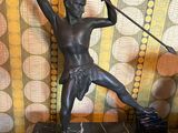 a statue of a man holding a spear on top of a table