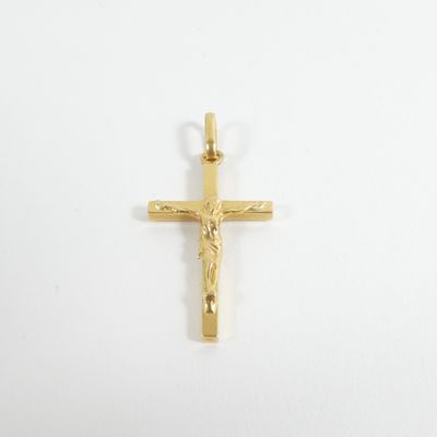 un pendentif en forme de croix en or sur lequel est représenté Jésus