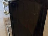a black stove sitting on top of a pallet in a warehouse