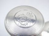 a close up of a silver object on a white surface