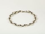 a close up of a silver bracelet on a white surface