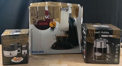 three boxes of coffee are sitting on a table with a coffee maker