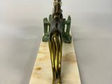 brass figurine of a woman sitting on a bench on a marble base
