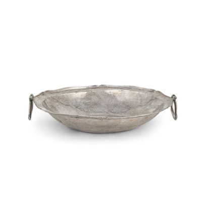 une assiette ancienne en argent avec une poignée, sur fond blanc