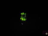 une lumière verte dans l'obscurité qui éclaire un téléphone portable