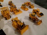 tout un tas de petits engins de chantier en plastique posés sur une table