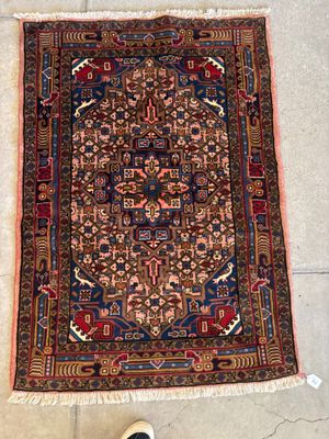 un gros plan sur un tapis posé par terre à côté d'une paire de chaussures