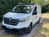 une camionnette blanche garée sur le bord d'un chemin de terre