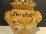 a yellow vase with a lid on a white table