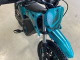 une photo d'une moto tout-terrain bleue garée dans un garage
