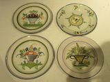 four plates with different designs on them on a white surface