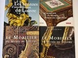 trois livres posés sur une table surmontée d'une statue en or