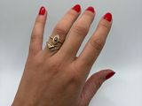 woman ' s hand with red manicured nails and a gold ring