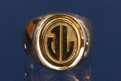 un gros plan d'une bague en or portant un monogramme