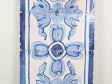 une photo d'une fresque murale en carreaux bleus et blancs accrochée à un mur