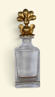 an image of a glass bottle with a gold flower on top