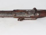 an old gun that is on display on a white surface
