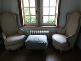 deux chaises et un pouf dans un coin de la pièce